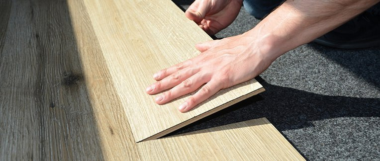 Ein Handwerker verlegt einen hochwertigen Bodenbelag aus Holz