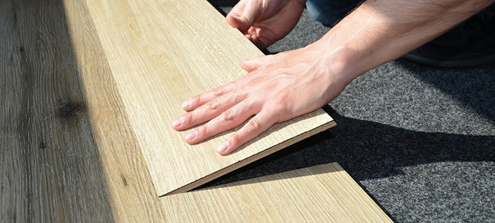 Ein Handwerker verlegt einen hochwertigen Bodenbelag aus Holz