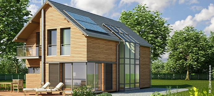Modernes Einfamilienhaus mit Holzfassade, großen Fensterfronten, Balkon und Solarpanelen auf dem Dach.